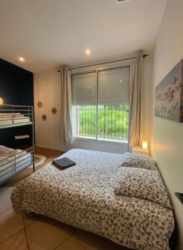 a bedroom with a bed and a large window at Authentique Mas provençal entre mer et Camargue in Marsillargues