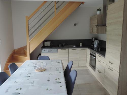 une cuisine avec une table et des chaises ainsi qu'un escalier dans l'établissement Gîte THIMAX, à Ablon