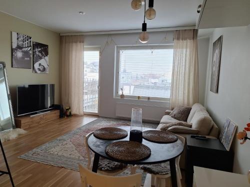 a living room with a table and a large window at Upea asunto ydinkeskustassa in Lappeenranta