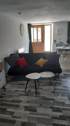 un salon avec un canapé noir et une table dans l'établissement Studio à Ban de Sapt, à Ban-de-Sapt