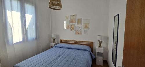 a bedroom with a blue bed and a window at La Casa Di Lele in Torre dell'Orso