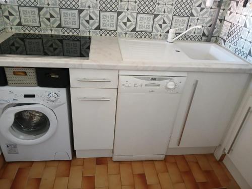 une cuisine avec un évier et une machine à laver dans l'établissement Charmant studio à Agde, 32 m² avec équipements modernes, au Cap d'Agde