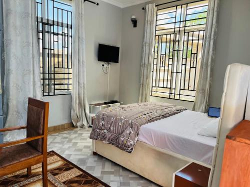 una camera da letto con un letto e due finestre di leo apartment ad Arusha