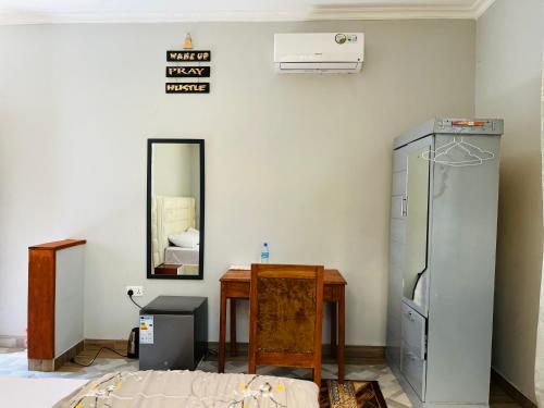 una stanza con un frigorifero, un tavolo e uno specchio di leo apartment ad Arusha