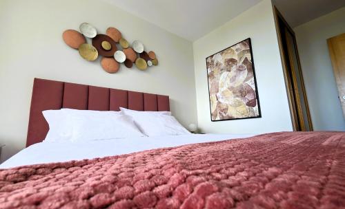 a bedroom with a large bed with a red blanket at Amorosa Beach Apartment Sea View in Viana do Castelo
