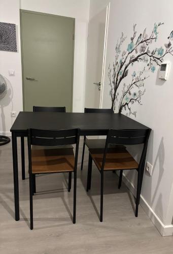 une table à manger noire avec deux chaises et un vase dans l'établissement Villejuif - Métro Léo Lagrange - 2 pièces avec balcon, à Villejuif