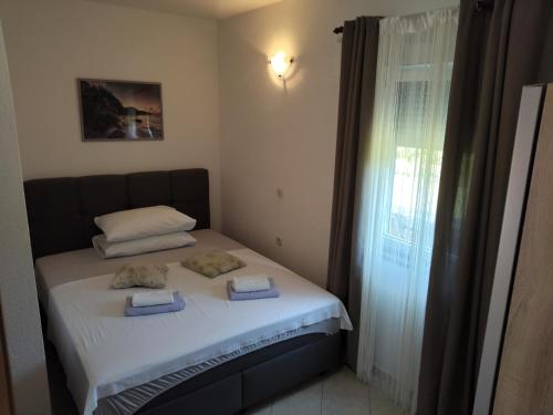 a small bed in a room with a window at Apartmani Mila-Casa Bianca in Medulin