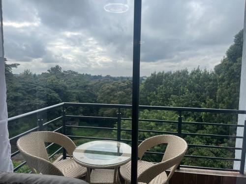 a table and chairs on a balcony with a view at Family friendly apartment in Nairobi
