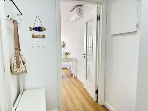 a hallway with white walls and a door leading into a room at Encantador apartamento com piscina in Costa da Caparica
