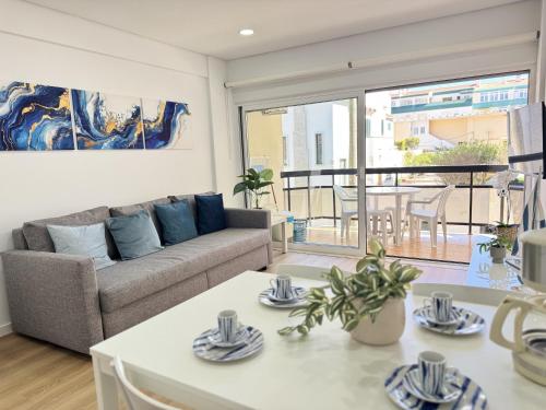 a living room with a couch and a table at Encantador apartamento com piscina in Costa da Caparica