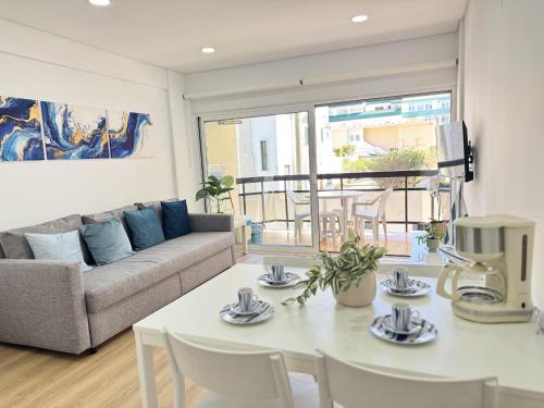 a living room with a couch and a table at Encantador apartamento com piscina in Costa da Caparica