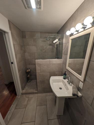 a bathroom with a sink and a shower and a mirror at BrewPub Bungalow #1 in Oakridge