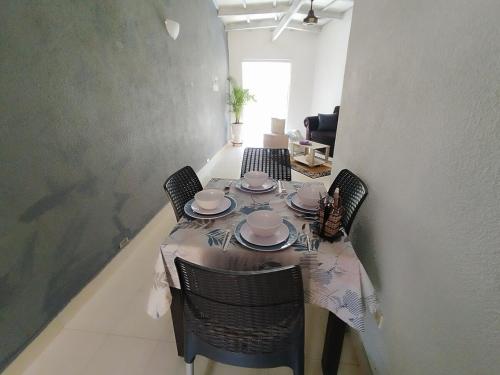 - une table à manger avec des chaises et des assiettes dans l'établissement Beautiful apartment in the Historic Center of Cartagena, à Carthagène des Indes