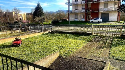 a small red car parked in a yard next to a fence at Appartamento da Cece - Filattiera in Filattiera
