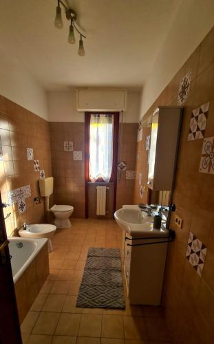 a bathroom with two sinks and a tub and a toilet at Appartamento da Cece - Filattiera in Filattiera