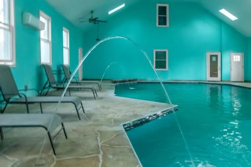 a swimming pool with blue walls and chairs in a room at The Panola Mansion - Indoor Pool & Pavilion in Stockbridge