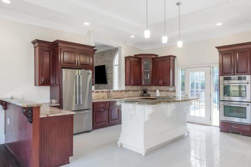 a kitchen with wooden cabinets and a large kitchen island at The Panola Mansion - Indoor Pool & Pavilion in Stockbridge