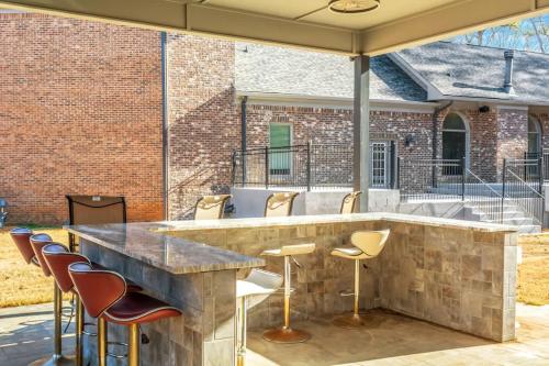 a large stone bar with stools in a patio at The Panola Mansion - Indoor Pool & Pavilion in Stockbridge