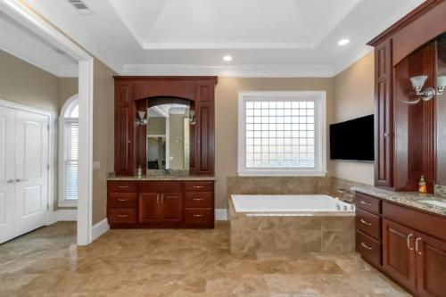 a large bathroom with a tub and a sink at The Panola Mansion - Indoor Pool & Pavilion in Stockbridge