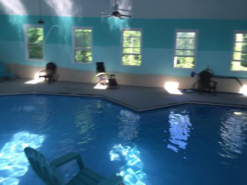 a swimming pool with a chair in a room at The Panola Mansion - Indoor Pool & Pavilion in Stockbridge