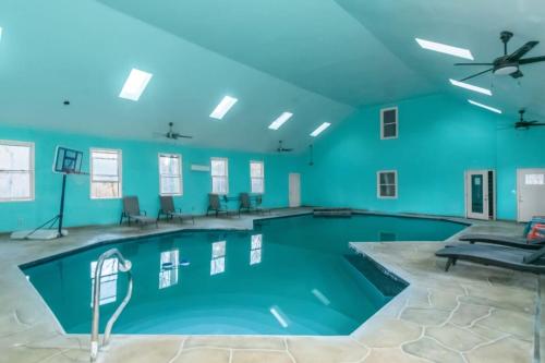 a large swimming pool with blue walls and a ceiling at The Panola Mansion - Indoor Pool & Pavilion in Stockbridge