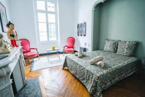- une chambre avec un lit et deux chaises rouges dans l'établissement Luxueux-Climatisation-3 chambres-2SDB-Garage -AJ, à Carcassonne
