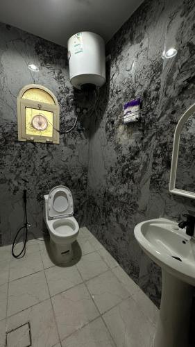 a bathroom with a toilet and a sink at شقه لليله جميله ومريحه in Al Khobar