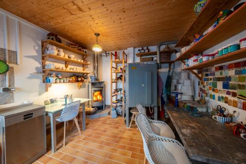 a kitchen with chairs and a table and a fireplace at Ferienhof am Trift in Bad Saarow