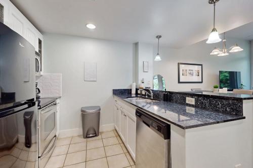 a kitchen with a counter top and a refrigerator at Baytowne Wharf - Observation Point North #555 in Destin