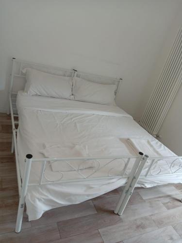 a white bed with white sheets and pillows at Via Battistelli Apartments in Bologna