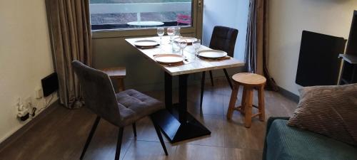 une table de salle à manger avec des chaises et des verres à vin dessus dans l'établissement Studio 4 personnes Vars les Claux 100m des pistes, à Vars