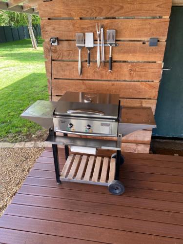 アルナージュにあるAux Premières Loges - Gîte de charme proche du circuitのデッキのテーブルにバーベキューグリル