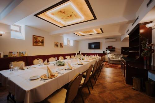 a dining room with a long table and chairs at Boutique Hotel Maraton in Košice