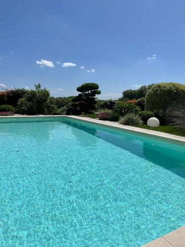 une grande piscine bleue dans une cour dans l'établissement Chambre indépendante avec piscine, à Jarnac