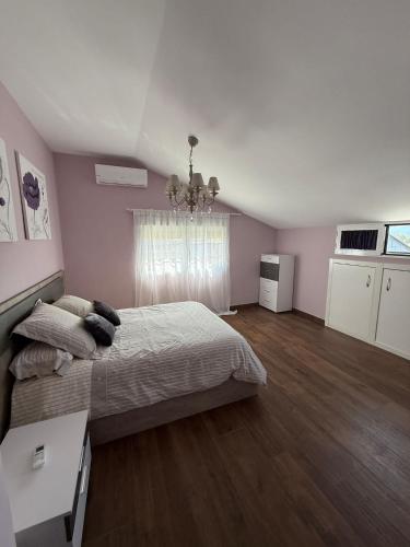 a bedroom with a bed and a chandelier at La casa amarilla in El Barraco