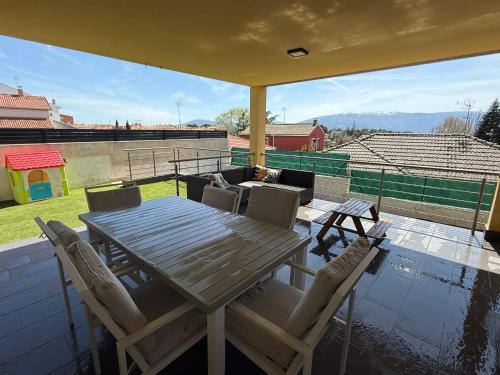 a wooden table and chairs on a balcony at La casa amarilla in El Barraco