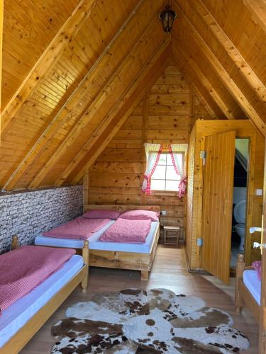 a bedroom with two beds in a wooden cabin at Smaka Brvnare in Sjenica