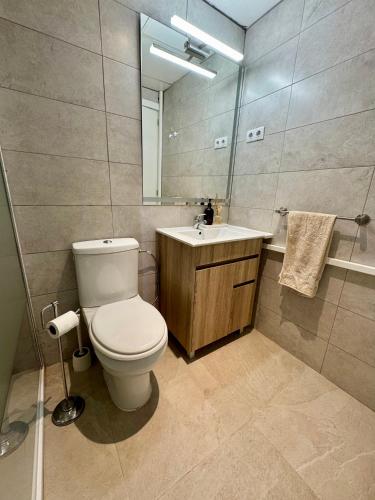 a bathroom with a toilet and a sink and a mirror at Apartamento completo junto a la playa in Salou