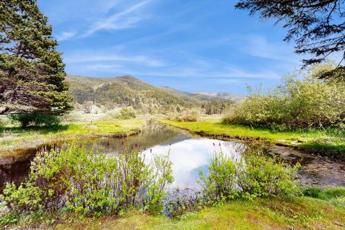 a river in a field with mountains in the background at Crescent Lake Lookout in Rockaway Beach
