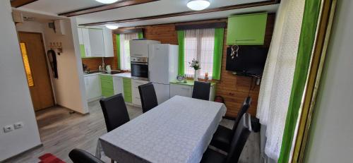 a kitchen with a table and a kitchen with green cabinets at Arijela - hiška v Čatežu 6-1 - Oaza sprostitve v Termah Čatež in Brežice