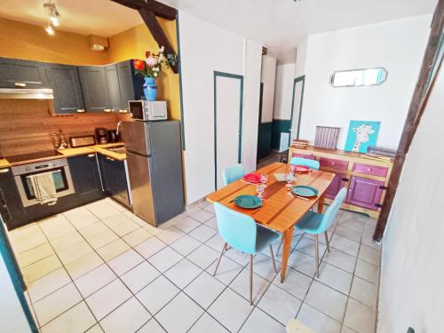 une cuisine avec une table en bois et des chaises bleues dans l'établissement Idéal famille, proche gare et centre-ville, parking gratuit, à Châlons-en-Champagne