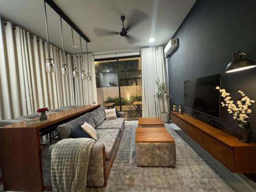 a living room with a couch and a flat screen tv at Transit Designer Home in Negombo in Negombo