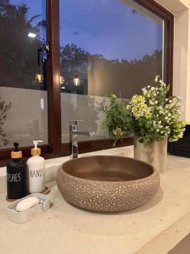 a bathroom with a bowl sink and a window at Transit Designer Home in Negombo in Negombo