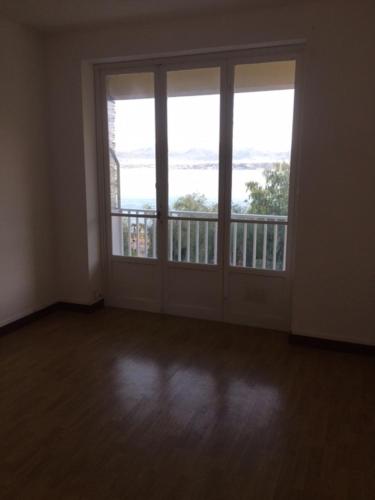 une chambre vide avec une grande porte et un balcon dans l'établissement appartement LE CLAN, à Bastelicaccia