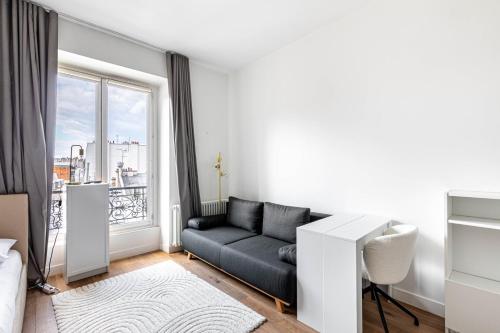 un salon avec un canapé et une fenêtre dans l'établissement Studio Bastille, à Paris