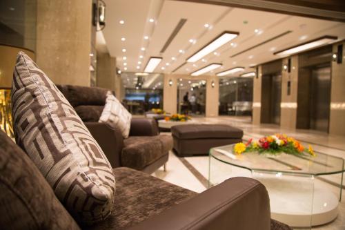 a living room with couches and a glass table at Kiscol Grands Hotel in Coimbatore