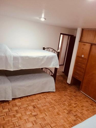 a bedroom with two bunk beds and a wooden floor at Departamento Sencillo Foro Sol GNP y Aeropuerto in Mexico City