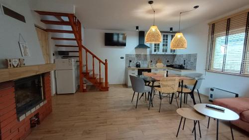a kitchen and living room with a table and chairs at Dom letniskowy do wynajęcia z własną Przystanią nad rzeką Narew - linia brzegowa in Dzbenin