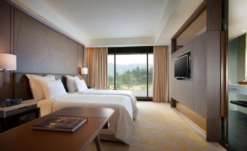 a hotel room with two beds and a television at InterContinental Bandung Dago Pakar by IHG in Bandung