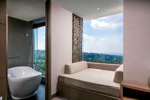 a bathroom with a bed and a tub and a window at InterContinental Bandung Dago Pakar by IHG in Bandung